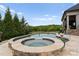 Luxurious pool and spa area with custom stone work and lush green landscaping with panoramic backyard views at 767 Pinnacle Dr, Iron Station, NC 28080