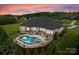 A luxury home featuring a pristine pool, spa, and landscaped patio overlooking the lush backyard at 767 Pinnacle Dr, Iron Station, NC 28080