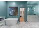 Modern bathroom with a soaking tub, marble floors, and an open doorway at 974 Queens Rd, Charlotte, NC 28207