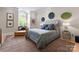 Comfortable bedroom featuring modern decor, a lounge chair, and a large arched window for plenty of natural light at 974 Queens Rd, Charlotte, NC 28207