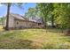 Wide shot of the back exterior featuring a fenced-in backyard with green grass and a wooden deck at 10139 Arlington Church Rd, Mint Hill, NC 28227