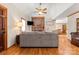 Living room with brick fireplace, hardwood floors, ceiling fan, and a view into the dining room at 10139 Arlington Church Rd, Mint Hill, NC 28227