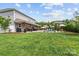 Expansive green backyard with a covered patio, outdoor seating, and a stunning pool at 106 Wrangler Dr, Mooresville, NC 28115