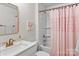 Bright bathroom featuring a tub with pink shower curtain, modern vanity, and decorative mirror at 106 Wrangler Dr, Mooresville, NC 28115