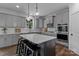 Modern kitchen with gray cabinets, quartz countertops, stainless steel appliances, and large island at 106 Wrangler Dr, Mooresville, NC 28115