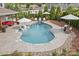 Relaxing in-ground pool with lounge chairs, umbrellas, and a serene waterfall feature at 106 Wrangler Dr, Mooresville, NC 28115