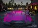Beautiful in-ground pool illuminated with vibrant pink lights, enhancing the nighttime ambiance at 106 Wrangler Dr, Mooresville, NC 28115