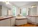 Bright bathroom featuring a soaking tub, double vanities, and wood flooring at 1106 3Rd Sw Ave, Hickory, NC 28602