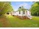 Exterior view of the home's side and back, including a grassy yard, staircase, and a detached garage at 1106 3Rd Sw Ave, Hickory, NC 28602