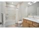 Clean bathroom with wooden vanity, shower-tub combo, and a decorative mirror at 1116 Brooksland Pl, Waxhaw, NC 28173