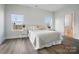 Cozy bedroom with a neutral color palette, two windows, and light-colored hardwood flooring at 1116 Brooksland Pl, Waxhaw, NC 28173