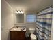 Bathroom with a vanity and cabinet storage, toilet, and a shower with a blue-striped curtain at 116 Dove Ln, New London, NC 28127