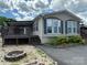 Charming home featuring well-maintained landscaping, flowerbeds, dark shutters, covered porch, and a fire pit at 116 Dove Ln, New London, NC 28127