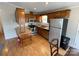 Well-lit kitchen featuring wooden cabinetry, stainless steel appliances, and laminate flooring at 116 Dove Ln, New London, NC 28127