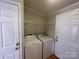 Functional laundry room with appliances, shelving, and door at 116 Dove Ln, New London, NC 28127