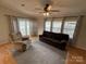 Comfortable living room featuring natural light, neutral paint, ceiling fan and stylish curtains at 116 Dove Ln, New London, NC 28127