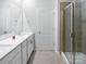 A bright bathroom with a double vanity, large mirror and a glass enclosed shower at 11933 Silverheel Ln, Huntersville, NC 28078