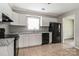 Bright kitchen featuring white cabinets, updated countertops, and modern black appliances at 1204 Glenarden Dr, Rock Hill, SC 29730