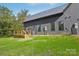 Home with black siding and metal roof, AC units, with a small wooden deck at 122 Laura Rd # A, Mooresville, NC 28117