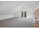 A spacious bedroom with an A-frame ceiling, ceiling fan, and double doors to the outside at 122 Laura Rd # B, Mooresville, NC 28117
