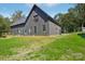 A modern home with a dark gray exterior, a metal roof, well-maintained lawn and lush green trees at 122 Laura Rd # B, Mooresville, NC 28117