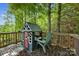 Charming backyard playhouse with a red door, a green chair, and situated among the trees at 13408 Portside Ln, Lancaster, SC 29720
