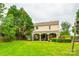 Well-maintained backyard featuring a lush green lawn, mature trees, and a covered patio area at 1418 Lonan Dr, Waxhaw, NC 28173