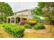 Landscaped backyard featuring a small pond, lush greenery, and a covered patio at 1418 Lonan Dr, Waxhaw, NC 28173