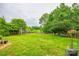 Large, expansive backyard perfect for outdoor activities, featuring mature trees and wooden fence at 1418 Lonan Dr, Waxhaw, NC 28173