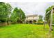 Spacious backyard with a well-manicured lawn, mature trees, and a swing set at 1418 Lonan Dr, Waxhaw, NC 28173