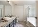 Bathroom with double sink vanity, marble countertops, glass shower and soaking tub at 1418 Lonan Dr, Waxhaw, NC 28173