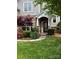 A welcoming front entrance featuring stone accents, a covered porch, and beautiful flowering shrubbery at 1418 Lonan Dr, Waxhaw, NC 28173
