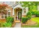 Charming front porch with stone pillars, floral decor, and a welcoming front door at 1418 Lonan Dr, Waxhaw, NC 28173
