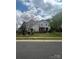 Beautifully landscaped front yard of this two-story home, featuring mature trees and a lush green lawn at 1418 Lonan Dr, Waxhaw, NC 28173