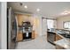 Bright kitchen with stainless appliances, light wood cabinets, and sliding barn door at 1418 Lonan Dr, Waxhaw, NC 28173