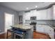 Bright kitchen with white cabinetry, stainless steel appliances, granite countertops, and a center island at 142 Aztec Cir, Mooresville, NC 28117