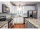 Modern kitchen featuring white cabinets, stainless steel appliances, granite countertops, and hardwood floors at 142 Aztec Cir, Mooresville, NC 28117