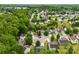 Aerial view highlighting the layout of a residential neighborhood nestled among lush, green trees and lawns at 1457 Mandy Place Ct, Charlotte, NC 28216