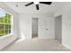 Well lit bedroom features neutral carpet, ceiling fan, and window overlooking backyard at 1457 Mandy Place Ct, Charlotte, NC 28216