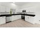 Bright, modern kitchen featuring white cabinets, stainless steel appliances, and black countertops at 1457 Mandy Place Ct, Charlotte, NC 28216