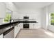 Bright, modern kitchen with white cabinets, stainless steel appliances, and black countertops at 1457 Mandy Place Ct, Charlotte, NC 28216