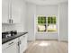 Bright kitchen nook with white cabinets, black counters, and large window with a tree view at 1457 Mandy Place Ct, Charlotte, NC 28216