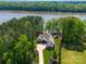 Stunning aerial view of a luxury waterfront home with lush landscaping and private dock at 1579 Sunset Pointe Dr, Salisbury, NC 28146