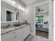Elegant bathroom boasts double granite vanity with mirrors, and view into bedroom overlooking lake at 1579 Sunset Pointe Dr, Salisbury, NC 28146