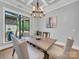 Well-lit dining room with a modern chandelier, natural wood table, and large window at 1579 Sunset Pointe Dr, Salisbury, NC 28146