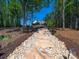 Long stone pathway leading up to grand home surrounded by lush greenery and blue sky at 1579 Sunset Pointe Dr, Salisbury, NC 28146