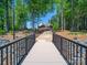 Scenic view of a lake house nestled among the trees, with a stone walkway and private dock at 1579 Sunset Pointe Dr, Salisbury, NC 28146