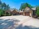 Impressive stone and brick home with arched entryway, three-car garage, and circular driveway at 1579 Sunset Pointe Dr, Salisbury, NC 28146