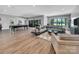 Open-concept living area with a pool table, comfortable seating, and lake views through expansive windows at 1579 Sunset Pointe Dr, Salisbury, NC 28146