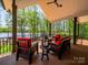 Covered porch featuring lake view and outdoor seating with red cushions at 1579 Sunset Pointe Dr, Salisbury, NC 28146